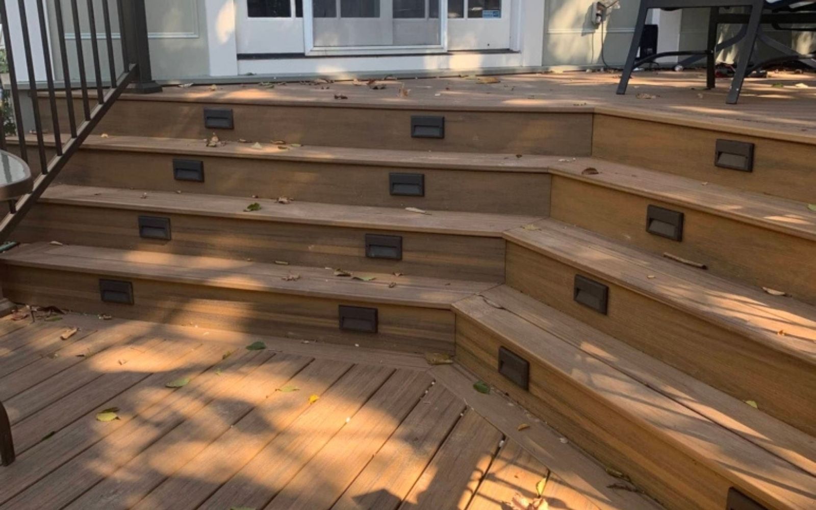 Composite deck with black aluminum railing and stone base